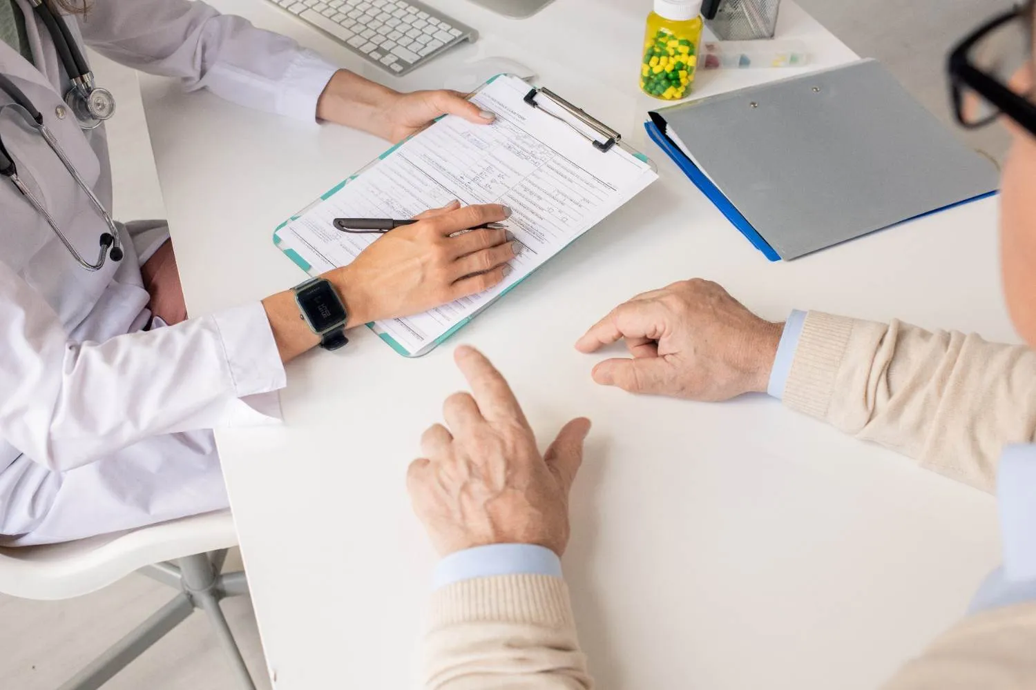 A doctor and a patient going over a form together at a desk