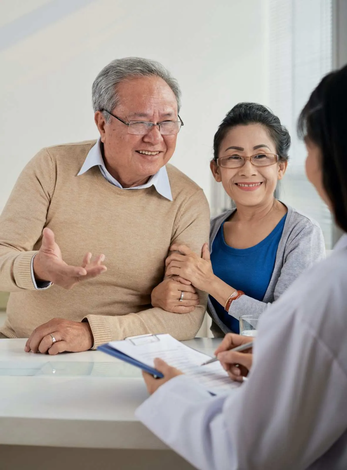 An older couple talking through coverage options across a desk